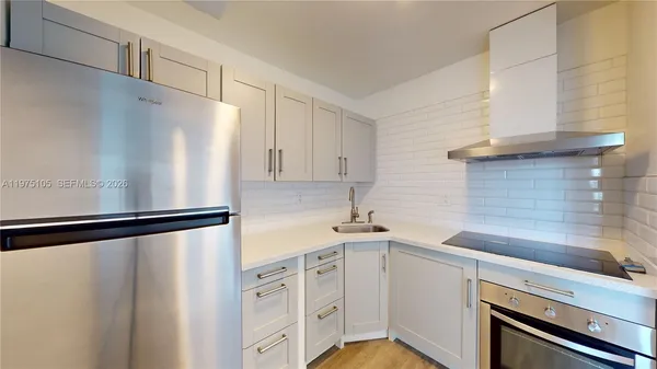 a kitchen with a refrigerator sink and cabinets