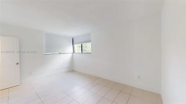 an empty room with white walls and windows