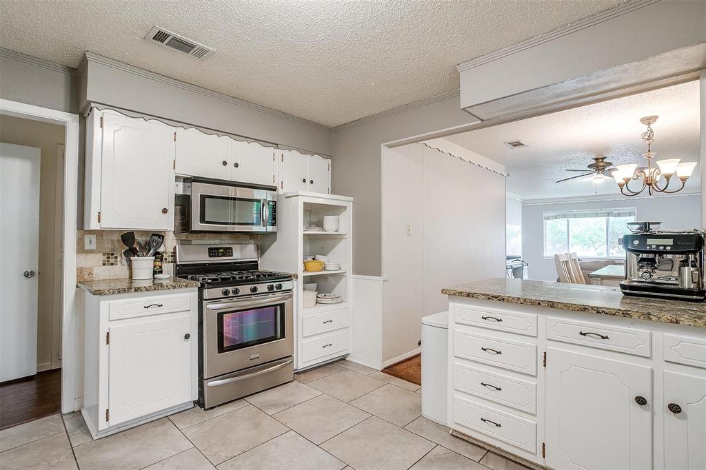 3217 Lubbock Avenue Fort Worth, TX 76109 - Photo 15 of 38 a kitchen with granite countertop white cabinets stainless steel appliances and a counter space