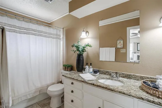 a bathroom with a shower curtain a mirror and a toilet