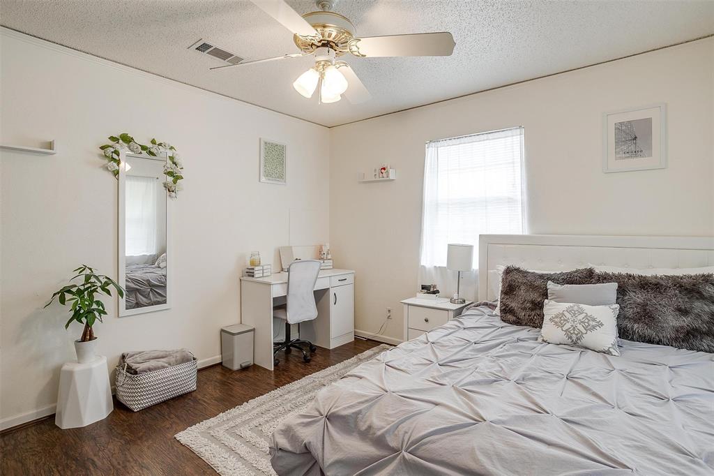 3217 Lubbock Avenue Fort Worth, TX 76109 - Photo 24 of 38 a bedroom with a bed and a chandelier
