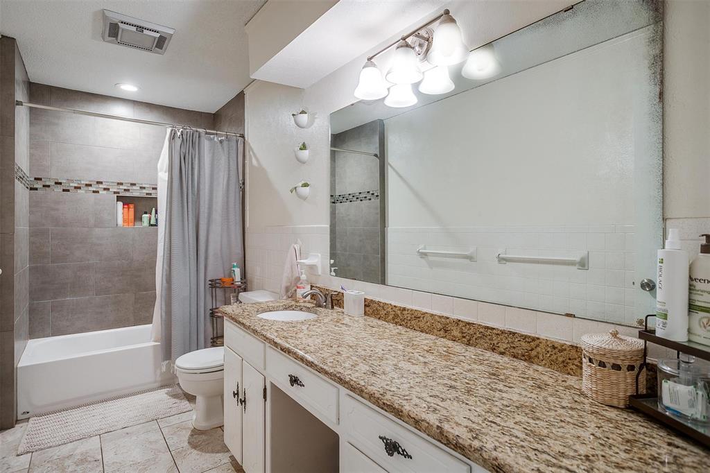 3217 Lubbock Avenue Fort Worth, TX 76109 - Photo 25 of 38 a bathroom with a granite countertop sink a toilet and shower