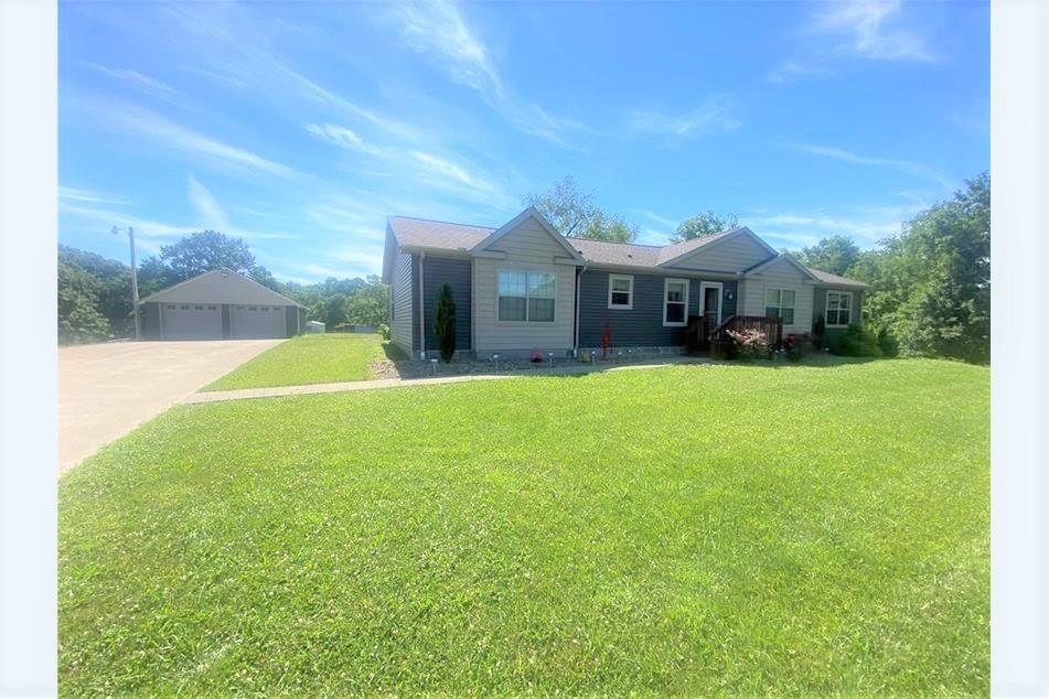 a front view of a house with yard and green space