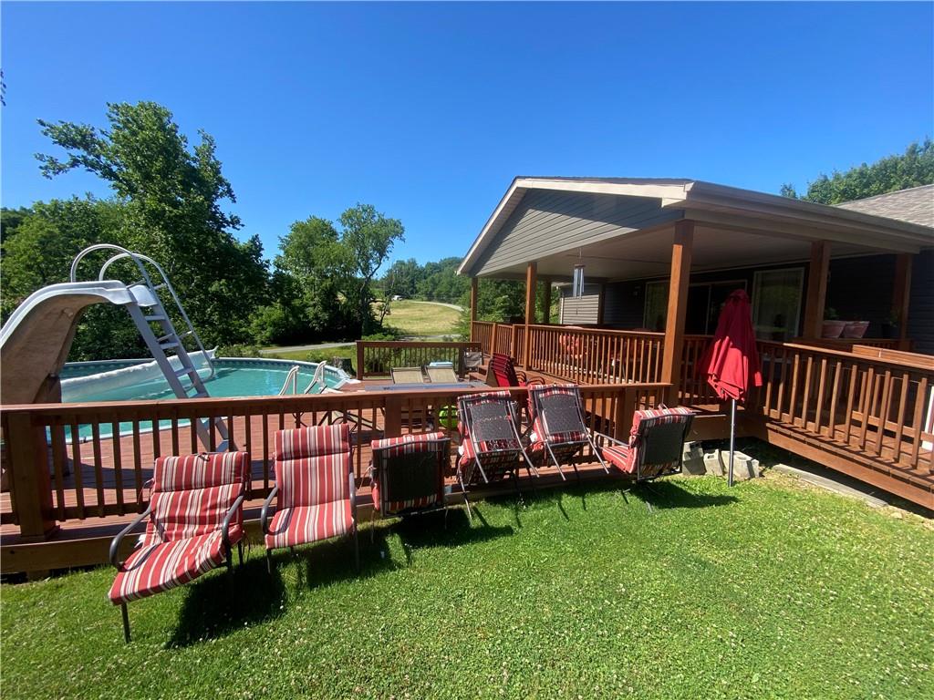 232 Center School Road Jefferson, PA 15344 - Photo 19 of 22 a view of a deck with a table and chairs under an umbrella with a yard