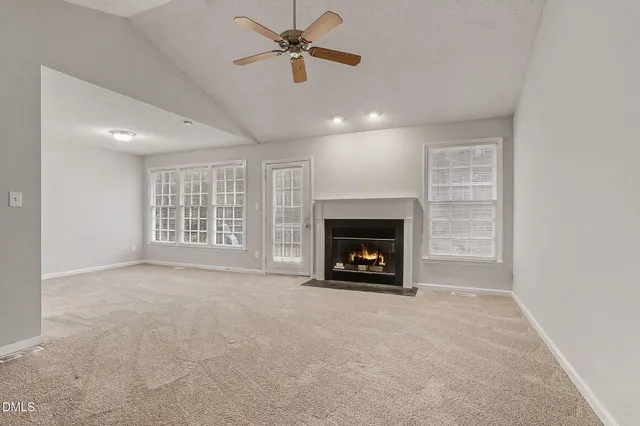 a view of an empty room with a fireplace and a window