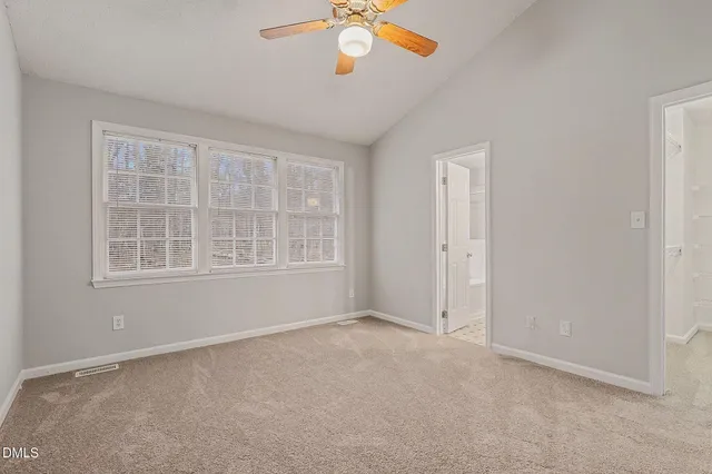 an empty room with chandelier fan