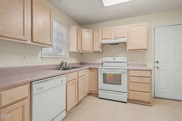 a kitchen with cabinets appliances a sink and a white cabinets