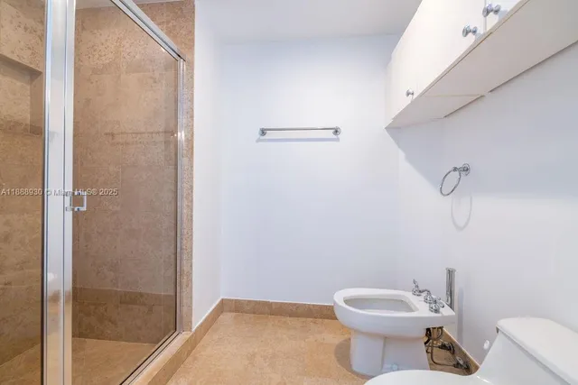 a white toilet sitting next to a bathroom sink
