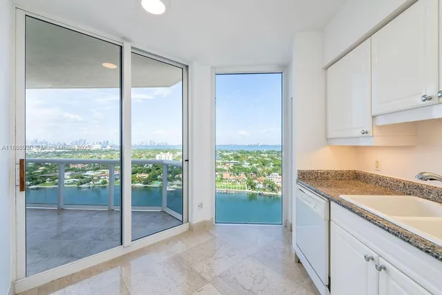 a spacious bathroom with a granite countertop sink and a large mirror next to a window
