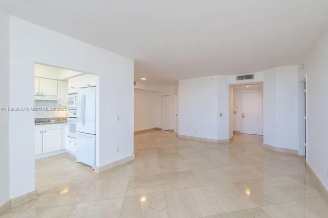 a view of a kitchen with white cabinets and stainless steel appliances
