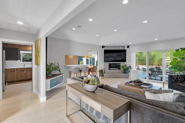 a living room with fireplace furniture and a large window