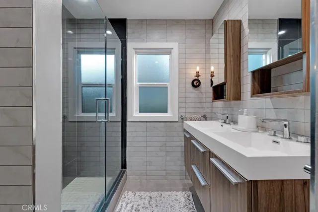 a bathroom with a double vanity sink a mirror and shower
