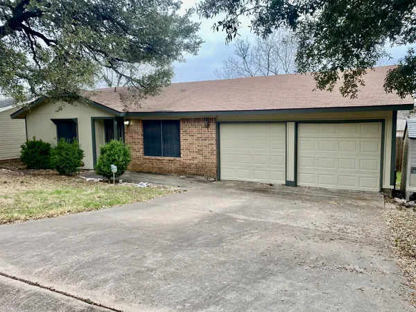a front view of house with yard and trees around