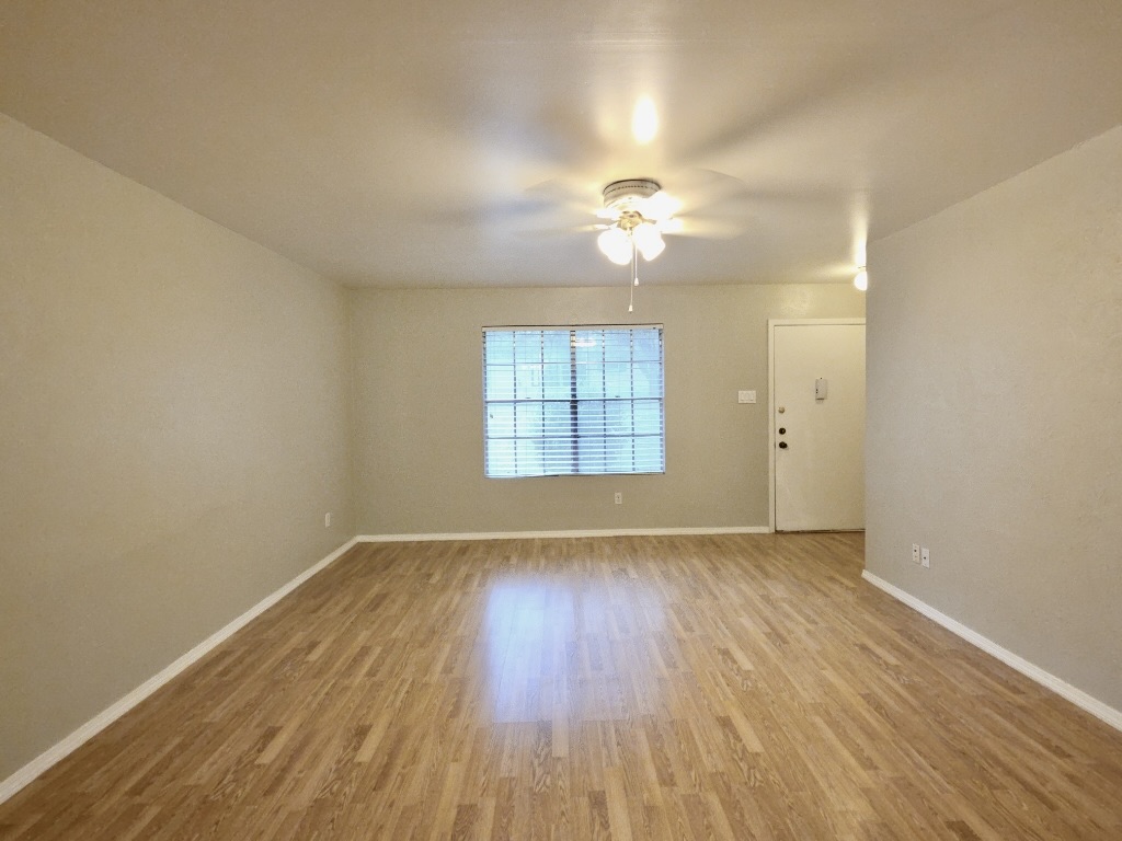 8508 Romney Road Austin, TX 78748 - Photo 2 of 21 an empty room with wooden floor chandelier fan and windows