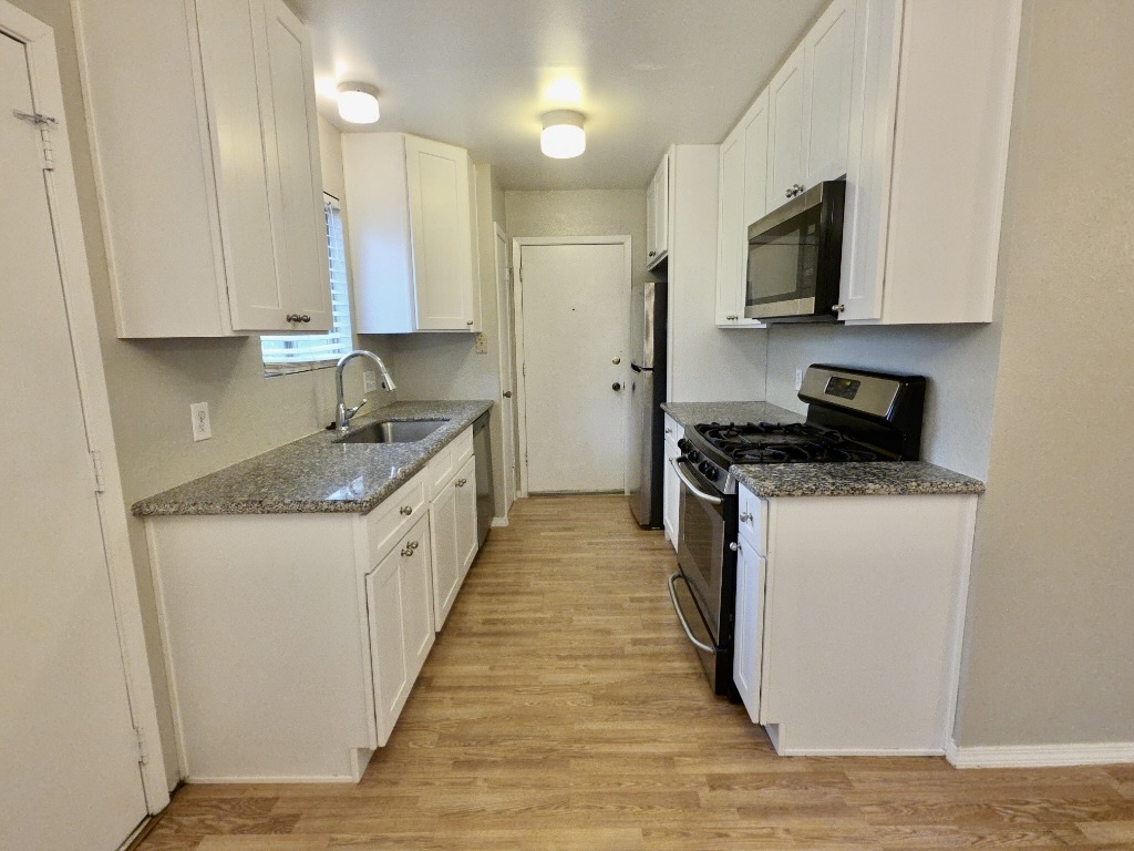 8508 Romney Road Austin, TX 78748 - Photo 6 of 21 a kitchen with granite countertop white cabinets and stainless steel appliances