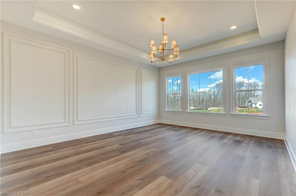 7688 Kyran Court Oak Ridge, NC 27310 - Photo 5 of 36 Primary suite with up-lit tray ceiling and custom wall moldings