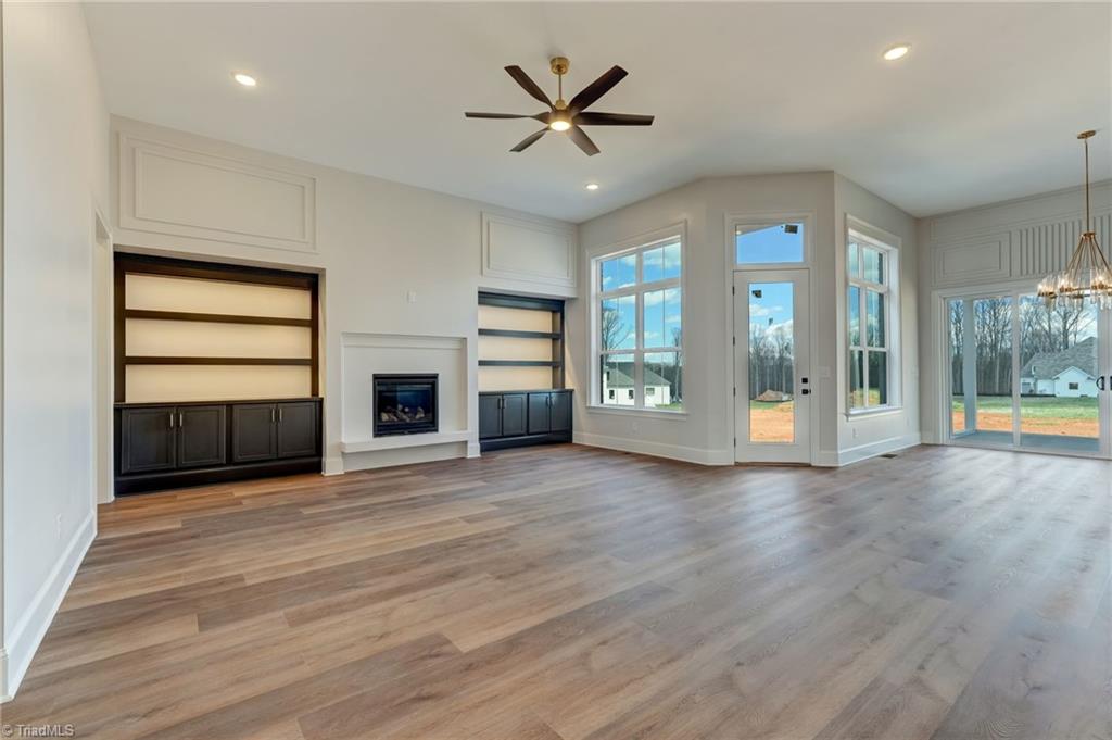 7688 Kyran Court Oak Ridge, NC 27310 - Photo 8 of 36 Great room features gas fireplace with floating hearth flanked by custom built ins with accent lighting