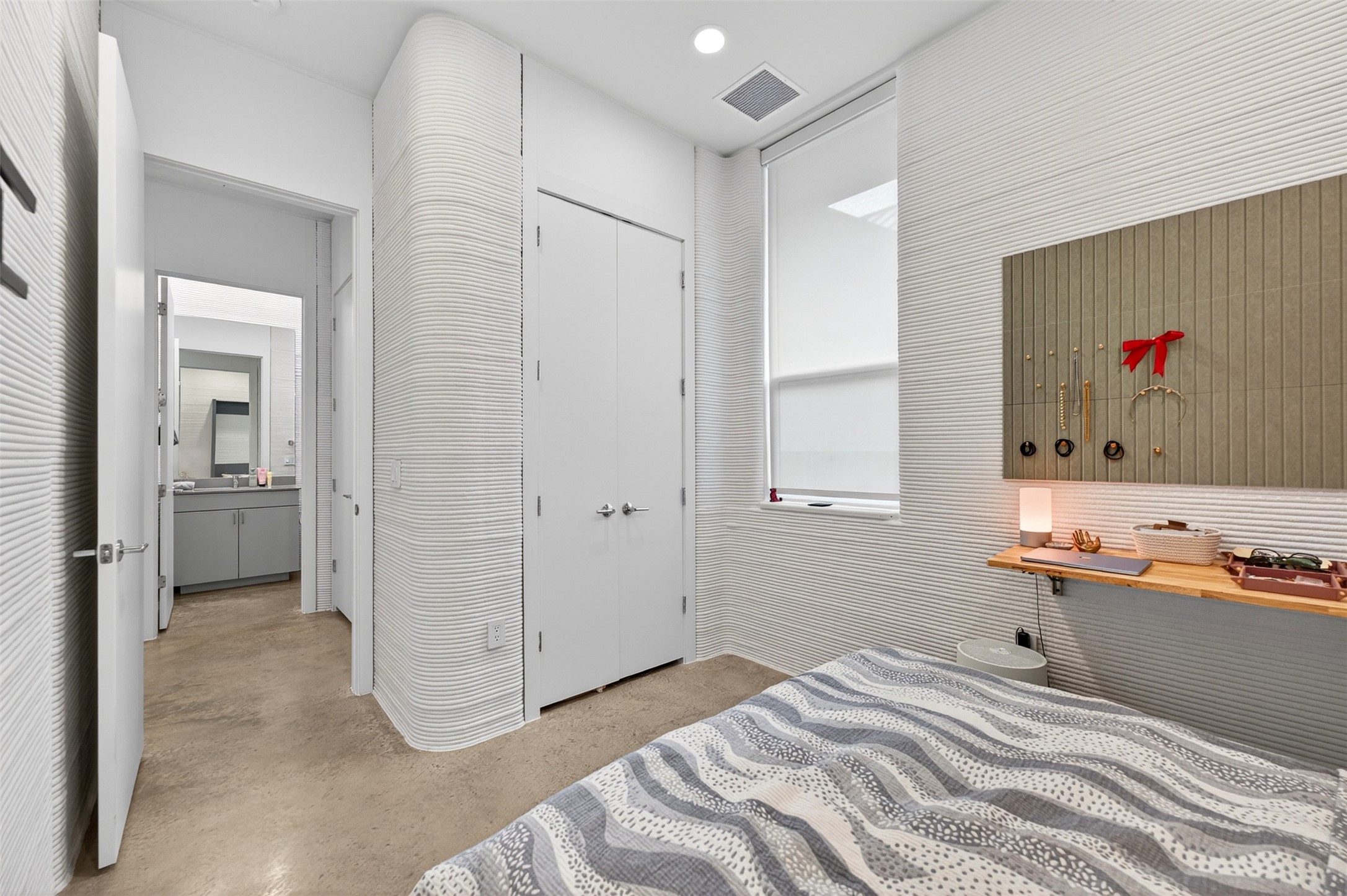 308 Painted Sunset Drive Georgetown, TX 78628 - Photo 16 of 26 Room featuring textured white walls, a built-in wood-finish shelving unit, a window with roller shade, and a closet with double doors