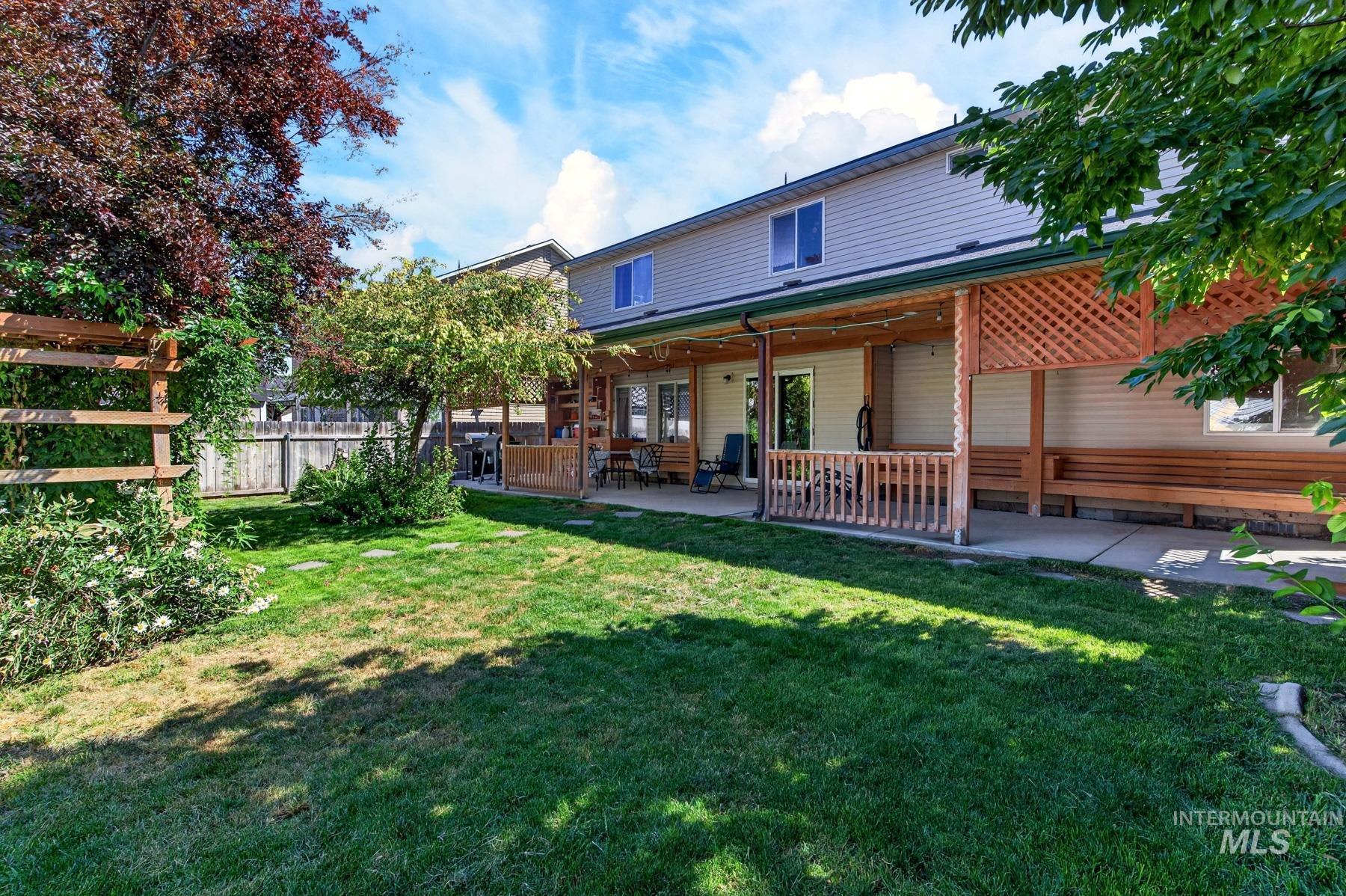 5020 Northrup Way Caldwell, ID 83607 - Photo 34 of 36 Spacious backyard featuring a covered patio, built-in wooden benches, and a lattice privacy screen