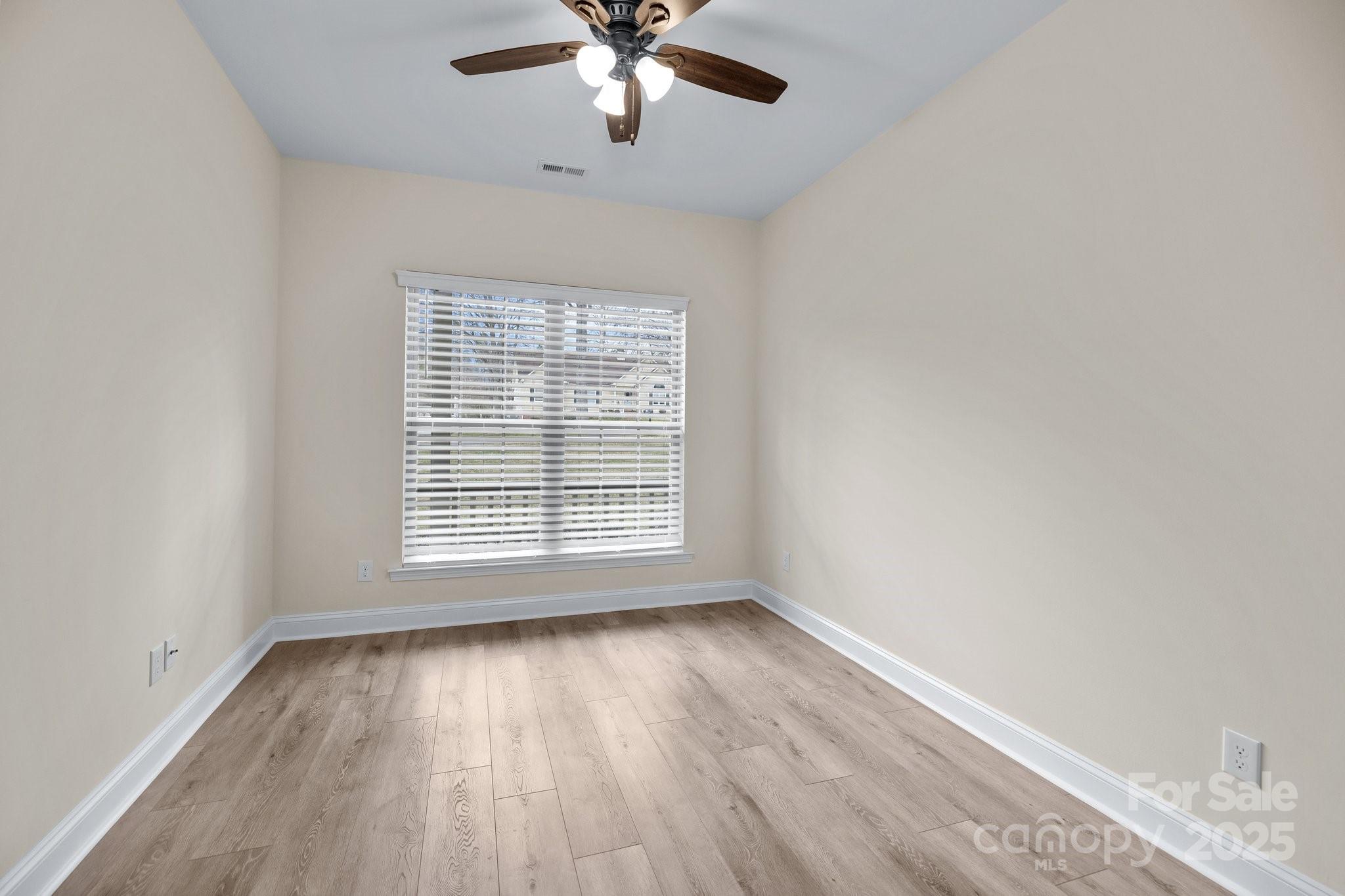 910 Pine Knoll Road, Unit 13 Fort Mill, SC 29715 - Photo 21 of 37 a view of an empty room with wooden floor and a window