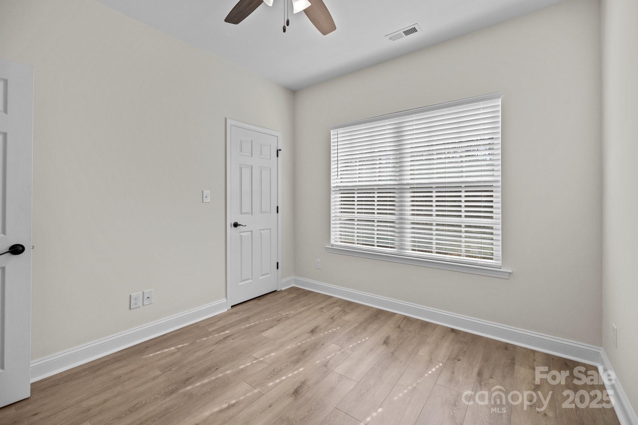 910 Pine Knoll Road, Unit 13 Fort Mill, SC 29715 - Photo 24 of 37 a view of an empty room with a window and wooden floor