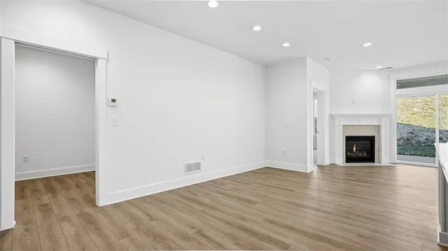 an empty room with wooden floor and fireplace