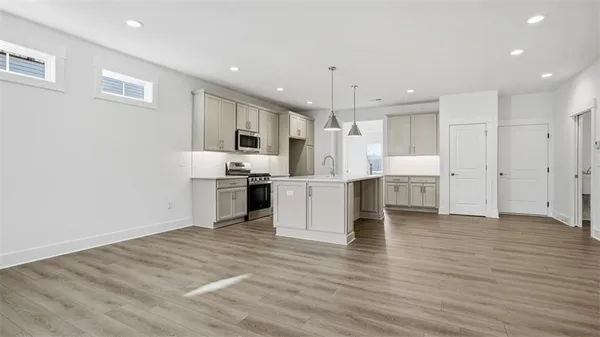 a large kitchen with kitchen island a sink stainless steel appliances and cabinets