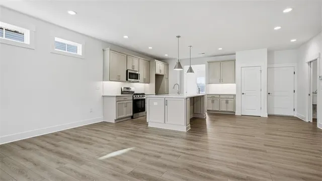 a large kitchen with kitchen island a sink stainless steel appliances and cabinets