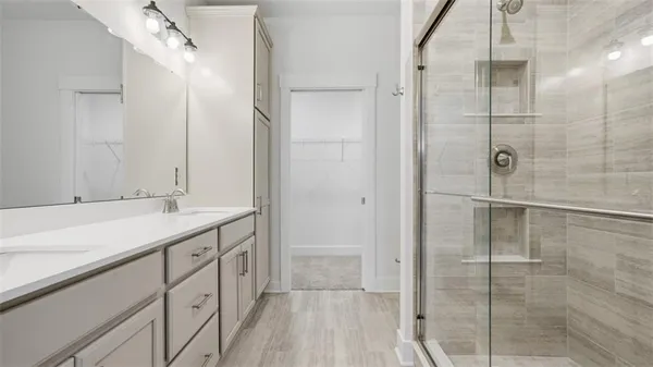 a bathroom with a shower sink and mirror