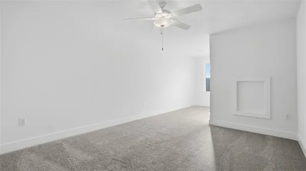 an empty room with chandelier fan