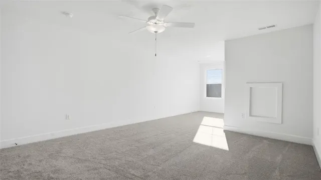 an empty room with chandelier fan