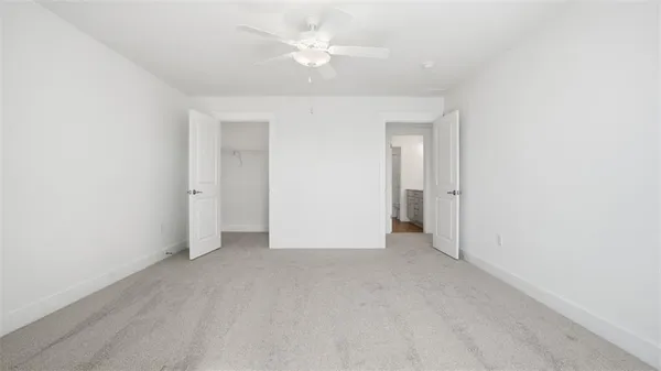 an empty room with a ceiling fan and a window