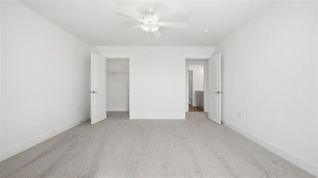 an empty room with a ceiling fan and a window