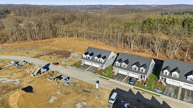 an aerial view of a house with a mountain