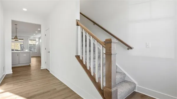 a view of a hallway with wooden floor and staircase