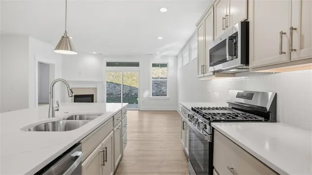 a kitchen with stainless steel appliances a sink a stove and cabinets