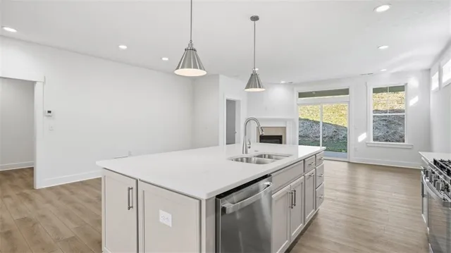 a kitchen that has a sink a stove and a wooden floor