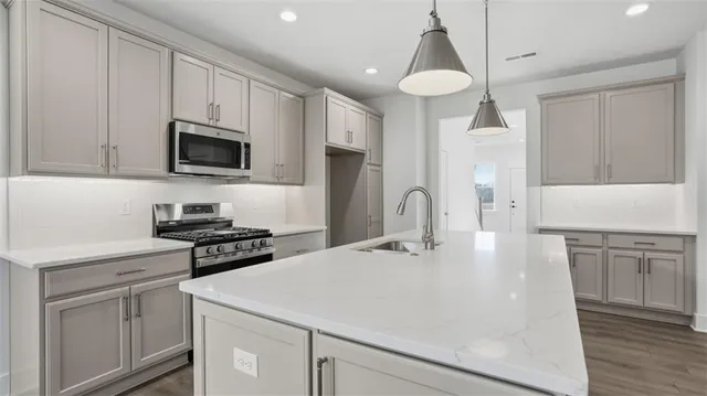 a kitchen with kitchen island a white cabinets and refrigerator