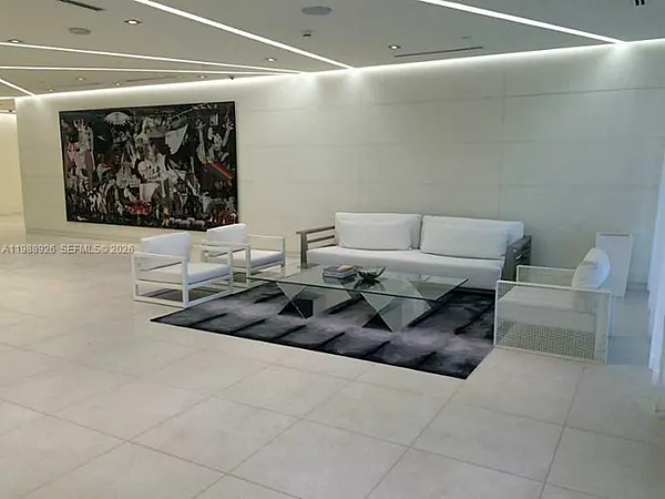 a living room with furniture a fireplace and a floor to ceiling window