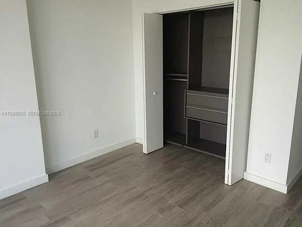 an empty room with wooden floor and closet