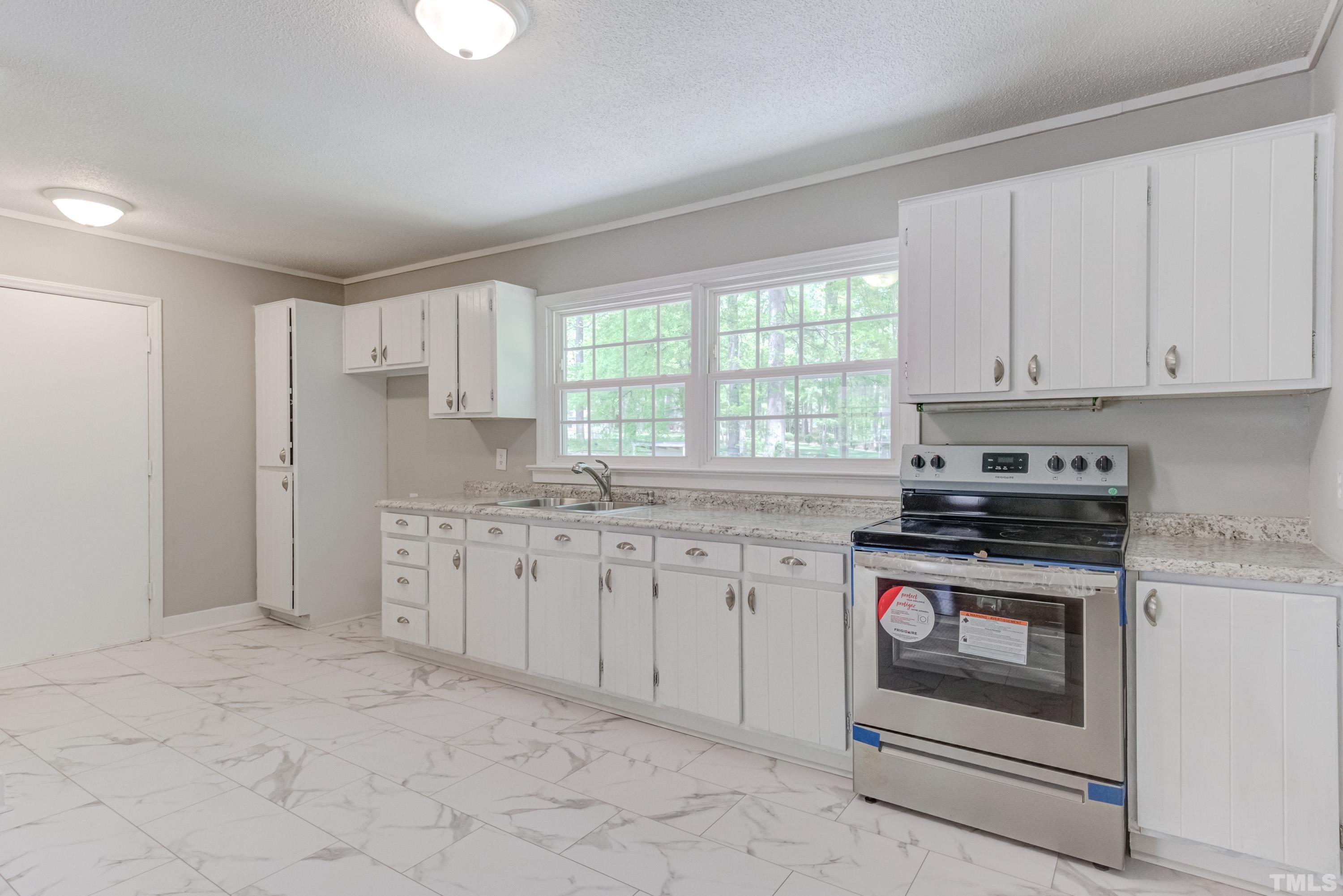 6005 Meadowbrook Road Raleigh, NC 27603 - Photo 11 of 42 a kitchen with granite countertop a stove sink and cabinets