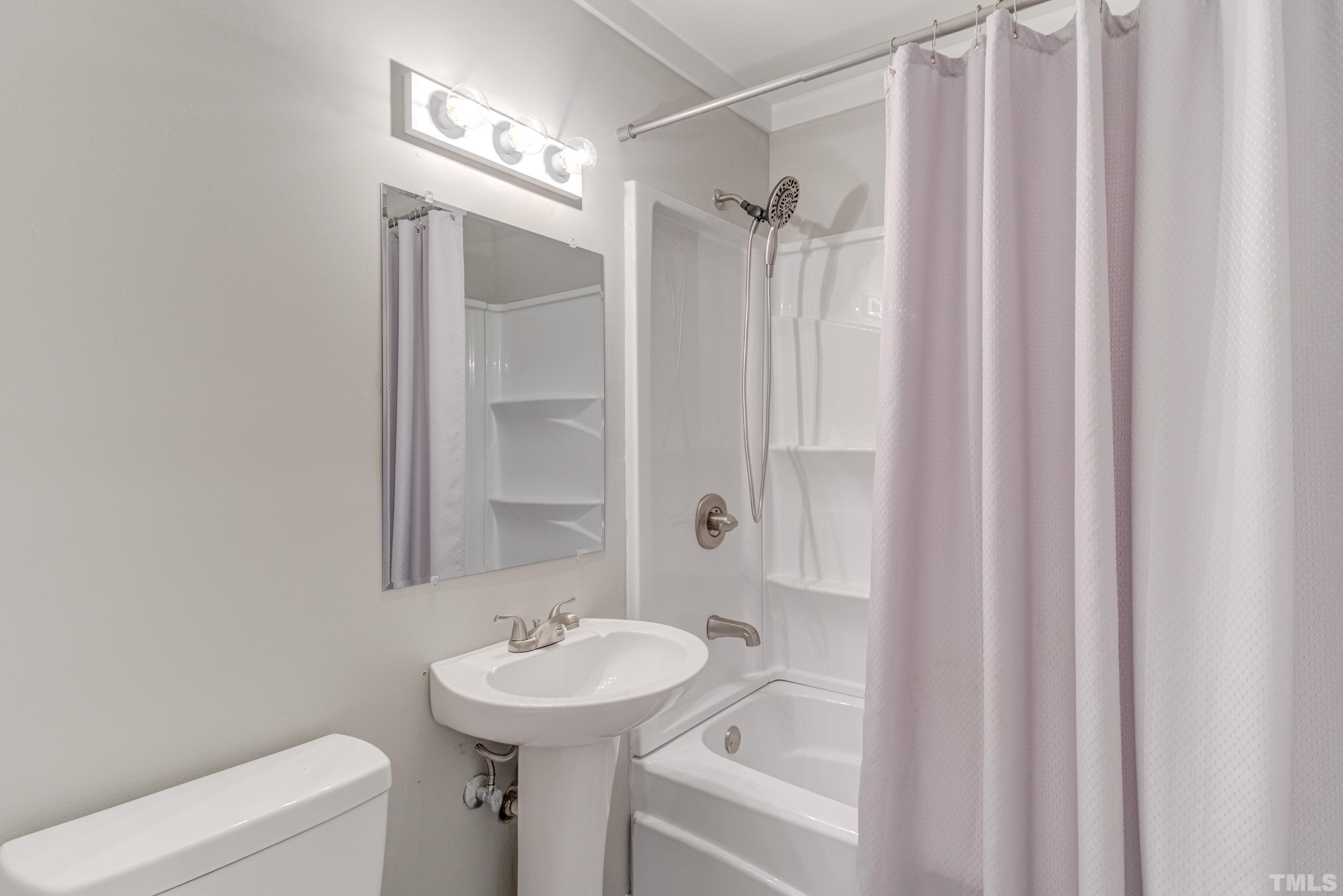 6005 Meadowbrook Road Raleigh, NC 27603 - Photo 23 of 42 a bathroom with a sink a toilet and shower