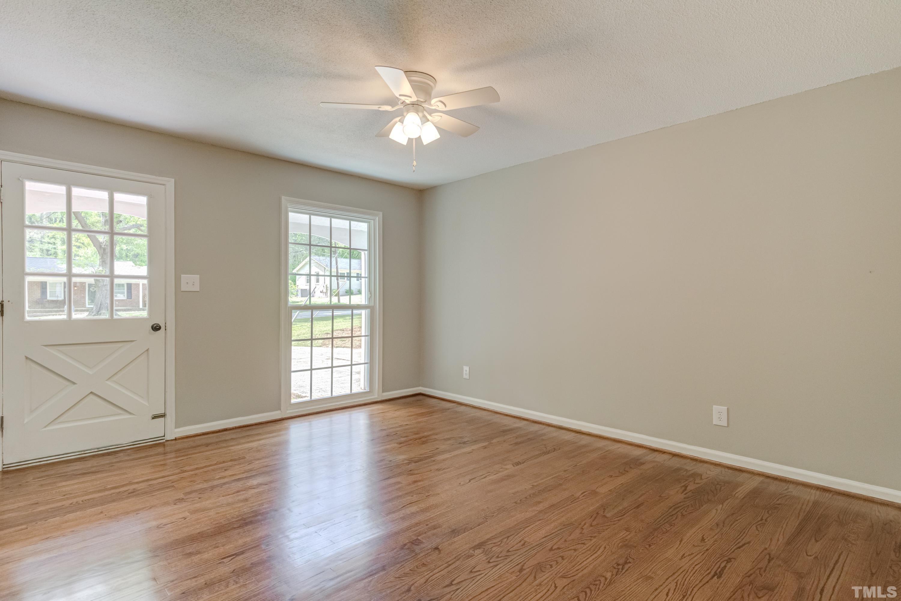 6005 Meadowbrook Road Raleigh, NC 27603 - Photo 3 of 42 a view of an empty room with wooden floor and a window