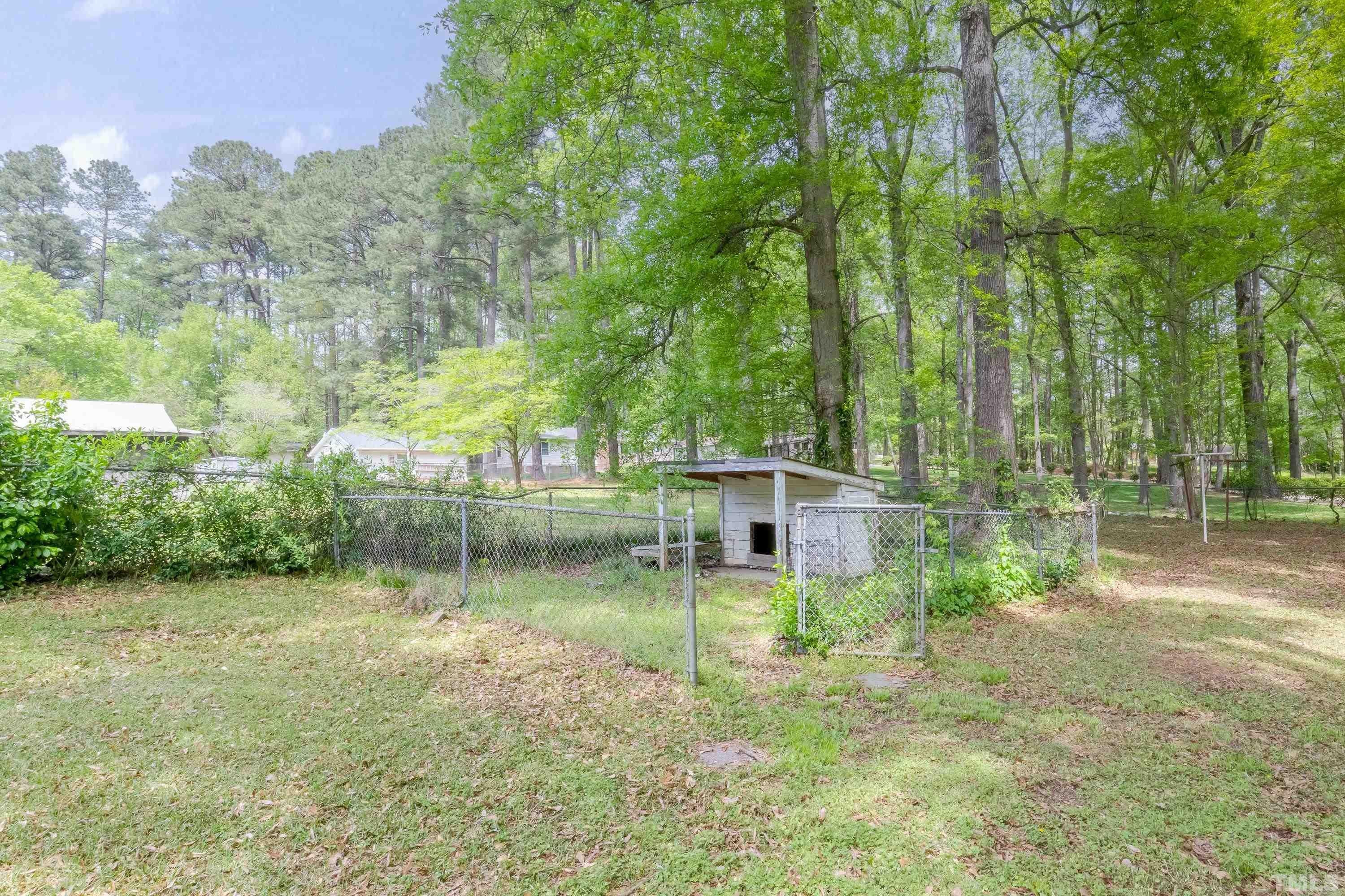 6005 Meadowbrook Road Raleigh, NC 27603 - Photo 31 of 42 a backyard of a house with lots of green space and fountain