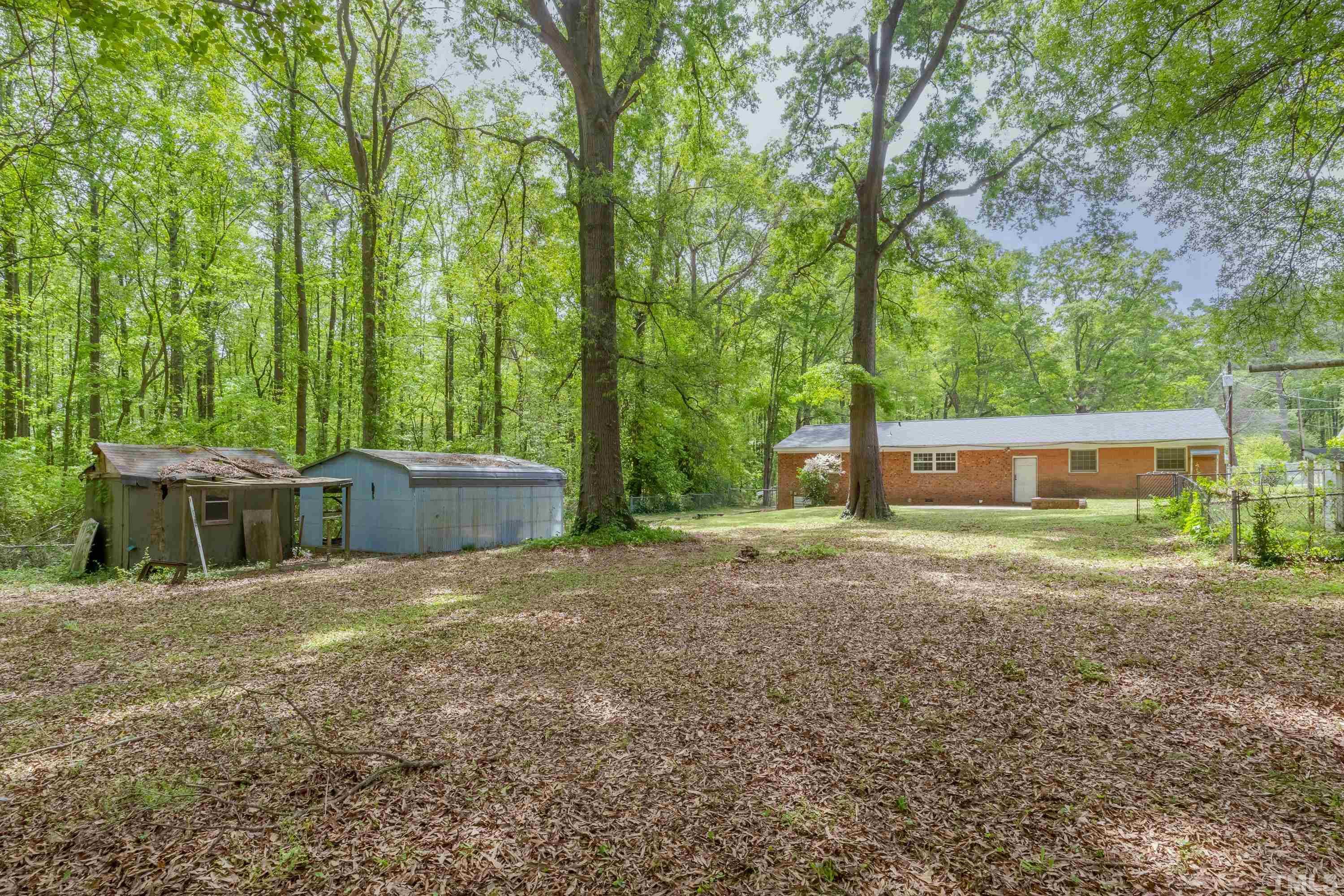 6005 Meadowbrook Road Raleigh, NC 27603 - Photo 32 of 42 a view of backyard with a barn and large trees