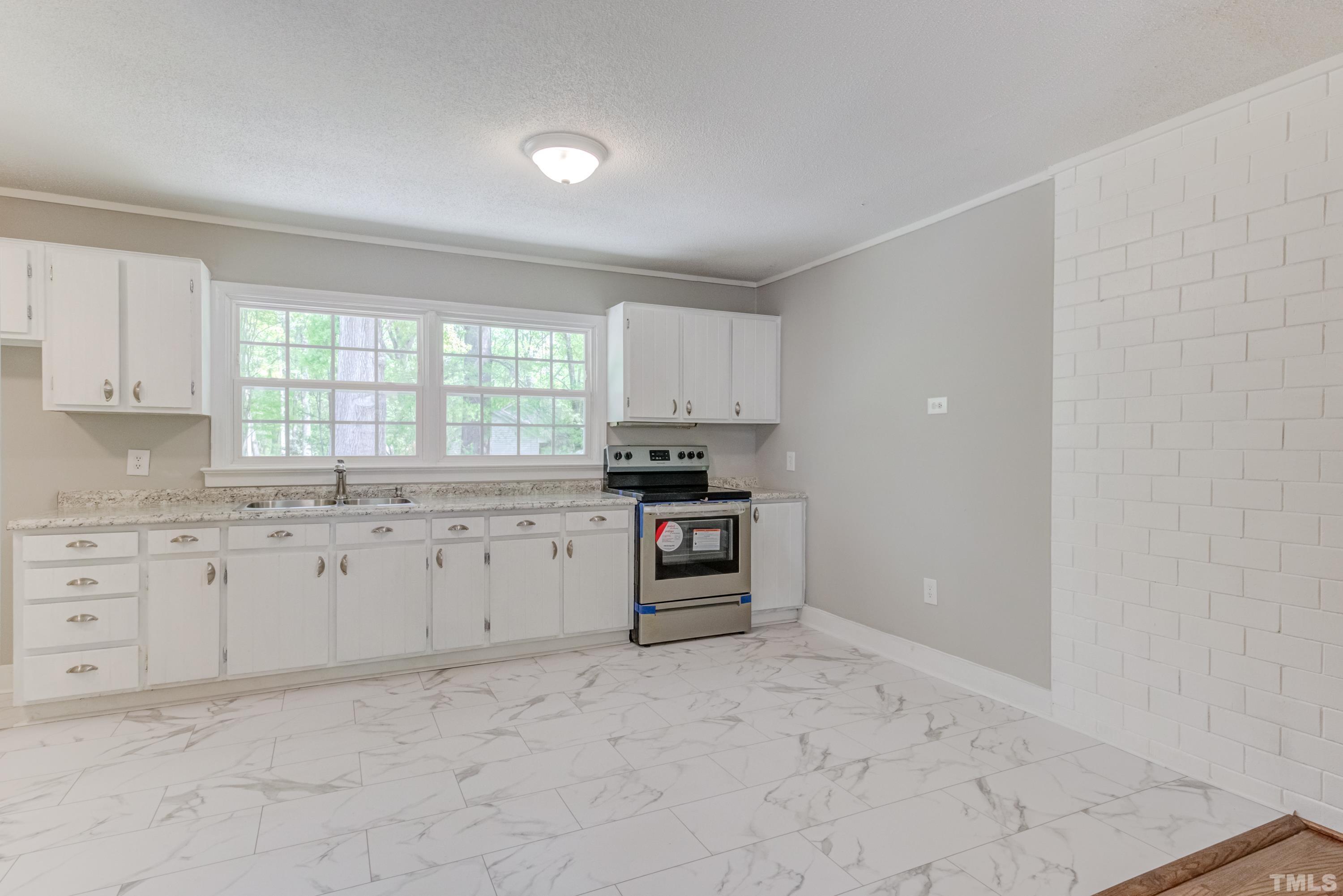 6005 Meadowbrook Road Raleigh, NC 27603 - Photo 7 of 42 a kitchen with granite countertop white cabinets and appliances