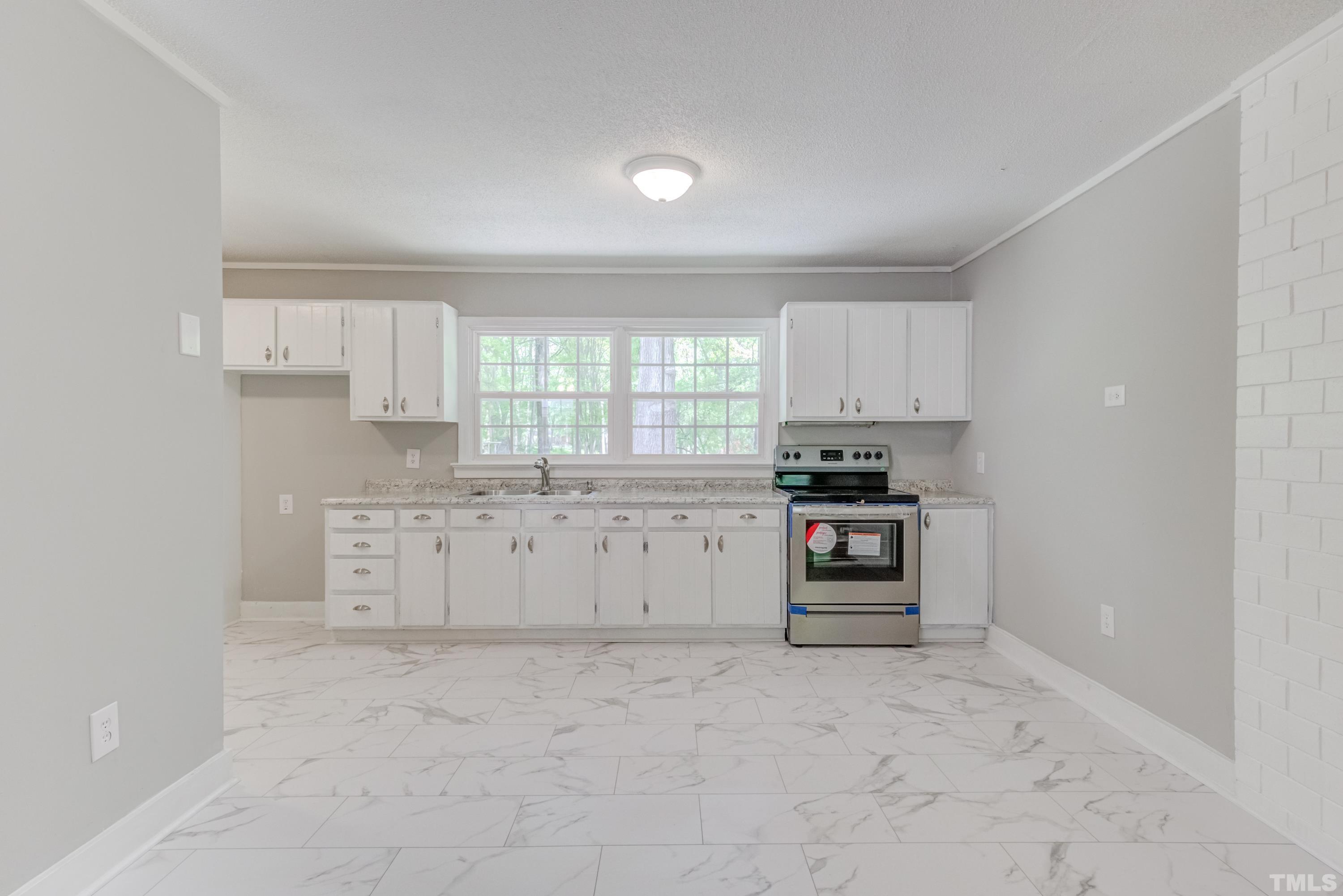6005 Meadowbrook Road Raleigh, NC 27603 - Photo 9 of 42 a kitchen with granite countertop a refrigerator and cabinets