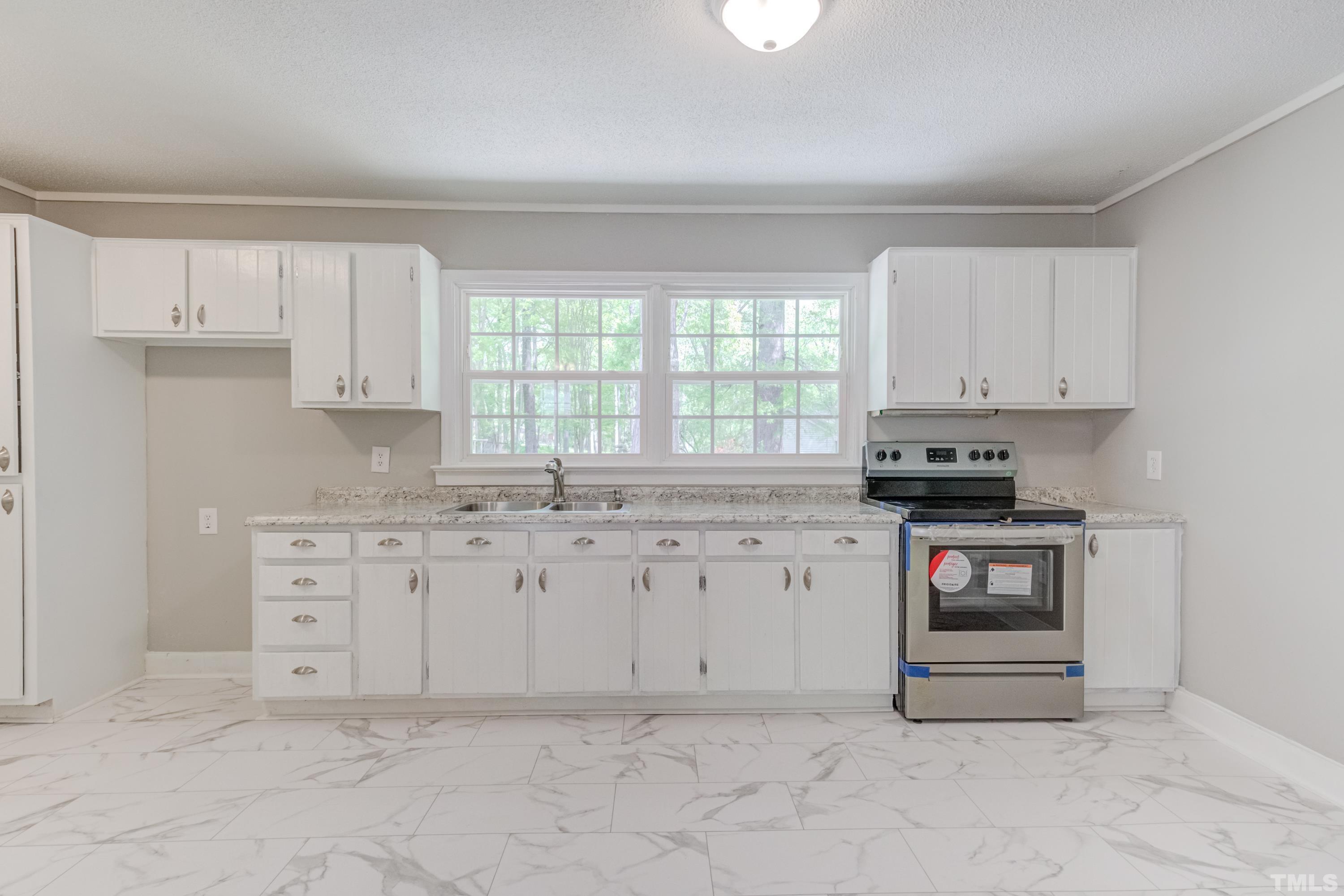 6005 Meadowbrook Road Raleigh, NC 27603 - Photo 10 of 42 a kitchen with granite countertop white cabinets white stainless steel appliances and a sink