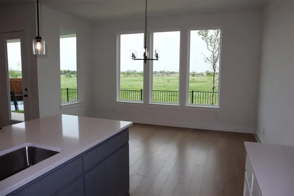 a kitchen with kitchen island a sink wooden floor and a large window