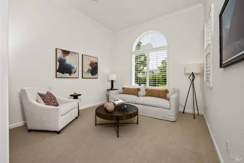 a living room with furniture a window and a flat screen tv